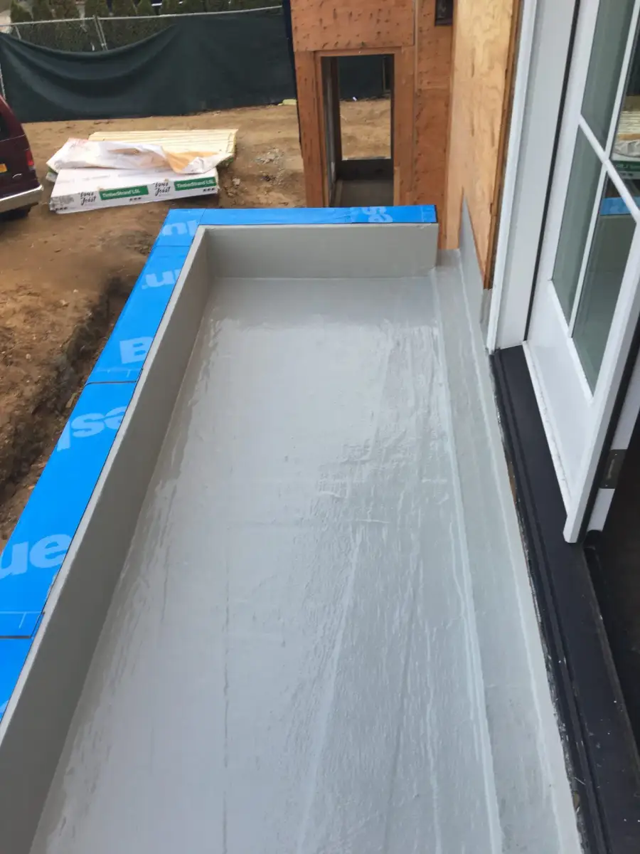 Balcony with fresh gray waterproofing membrane next to a window