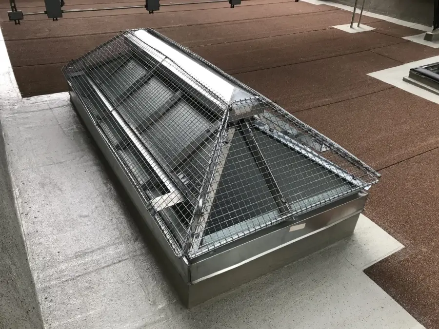Pyramid skylight with protective screen on a flat roof